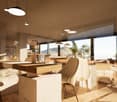 Spacious open-plan living and dining area with large windows offering a scenic view. The room features a wooden dining table with chairs, a sofa, and pendant lighting fixtures. The decor has a modern and minimalist style with neutral tones and natural mat