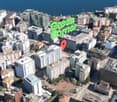 Aerial view of a densely populated urban area with high-rise buildings, including a large green sign that says 'Green Corner' visible in the center of the image.