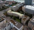 Buildings in a city with green spaces and cars on the street