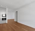 white walls, wooden floor, integrated oven and dishwasher, built-in cabinets, white countertops