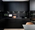 modern black cabinets, black countertop, double sink, oven, dishwasher, dark decor