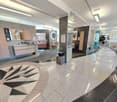 modern design, granite flooring, gray walls, wooden cabinets, glass mirrors, sinks, and toilets, central decorative element