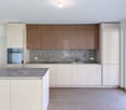Open kitchen, modern cabinets, island with countertop, built-in oven, granite countertop, marble backsplash, stainless steel sink, modern faucet, under-mount lighting