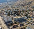 Cityscape with a mix of modern and traditional buildings, a construction site, and a parking area