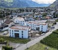 Aerial view of a group of houses, one under construction, with a view of the mountains.