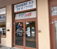 Entrance to a fitness center, double glass doors, brown wooden frame, sign above the door, open 24/7