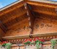 wooden exterior, balcony with flower boxes, year 1999 on the wall