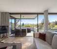 large windows, balcony with lounge chairs, sliding glass doors, open space