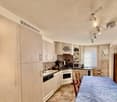 light kitchen with wooden cabinets, gas stove, dishwasher, washing machine, sink, microwave, windows