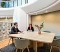 modern office, wooden desk, glass wall, round carpet, chairs, flowers