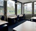Office setup with desks, chairs, and large windows