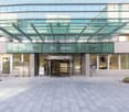 entrance of an office building with glass canopy, revolving door, signage for Nations Business Center
