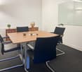 rectangular table, 4 black chairs, globe on the desk, white dry erase board, wooden cabinet, potted plant
