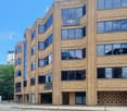 4 story building, brick, glass windows, Regus signage, cars visible on driveway