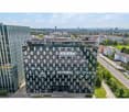 Modern office building, glass facade, several floors, adjacent building