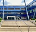 Blue modern building, multiple stories, Regus signage, concrete steps with metal railing