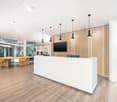 modern office, white desk, yellow chairs, wooden floor, glass walls, monitors, lamps
