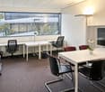 white walls, desks, chairs, window, trash bin, table, flower, TV monitor