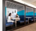A private office setting with a table, benches, and a wall-mounted charging station