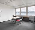 empty conference room with desks, chairs, whiteboard, and large windows