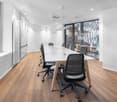 modern office room, white walls, wooden floor, long table, black chairs, glass windows, air conditioning
