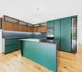 Modern kitchen with wood and teal cabinets, stainless steel appliances, and a central island with a countertop. The kitchen has a sleek and contemporary design with ample storage and workspace.