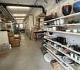 Interior of a store with white shelves filled with white ceramic ware and bowls