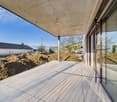 Modern house with glass walls, terrace on the first floor
