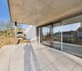 modern house with concrete tiles flooring, sliding glass doors, glass walls, ceiling light, terrace