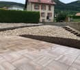 A tiled walkway in a garden with gravel and plants.
