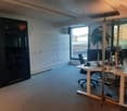 Open office space with desks, chairs, storage cabinets, office equipment and view of the city