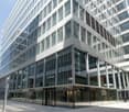 Modern office building, glass exterior, reflective windows, glass doors, metal accents, urban setting