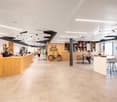 an open office space with desks, chairs, a reception area, bicycles, and shelves with books