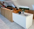 wooden reception desk, white counter top, flower vase, modern chairs, radiators, office plants
