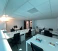 modern office, white desks, black chairs, grey carpet, lit from above