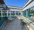tiled floor, metal benches, glass railings, clear sky