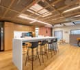 Large countertop, wooden floor, modern design, wooden cabinets, bike, snack machine