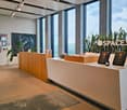 modern reception area with large windows, wooden counter, awards, plants, framed pictures on the wall