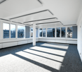 Empty room with white walls, gray carpet, large windows, central column