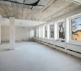 white painted walls, clean concrete floor, several large windows, exposed beams