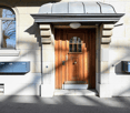 Stone exterior building, wooden entrance door, metal mailbox.