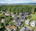 group of houses in forested area, solar panels, multiple terraces, views of the city