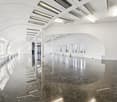 Empty room, marble flooring, white walls, arched design, multiple windows, recessed ceiling lights, no furniture
