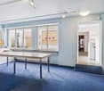 empty room, white walls, blue carpet, long table, windows, open door