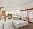 empty room, white walls, white ceiling, white floor, white tables, white cabinets, white display table, white display stand, white plastic bags, wooden door, wooden frames, lights on ceiling