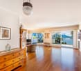wooden floor, large windows with balcony overlooking the lake and mountains