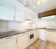 Spacious kitchen with white cabinets, granite countertops, built-in oven, and dishwasher