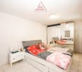 a bedroom with a bed, nightstands, a mirror, a closet, and a lamp