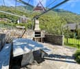 Stone seating area, outdoor table, stone bench, stone wall, fireplace, metal roofing, open area, mountains