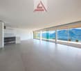 open floor plan, large sliding glass doors, neutral colored flooring, white walls, panoramic view
